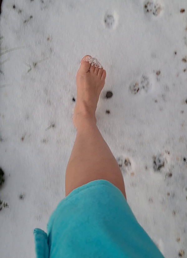 Ich wage einen kurzen Spaziergang barfuß durch den Schnee.